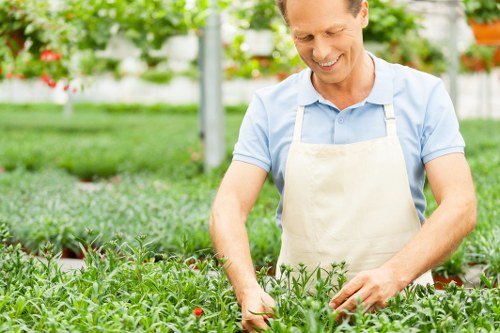 Worker wearing PPE preparing equipment before garden maintenance
